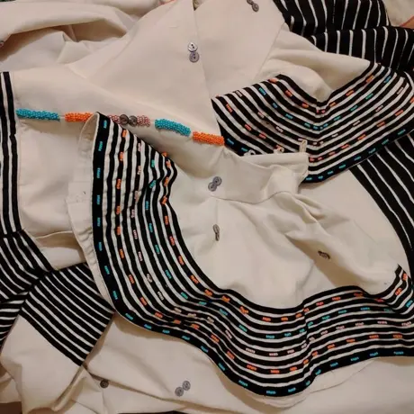 Beadwork detail on a striped yoke